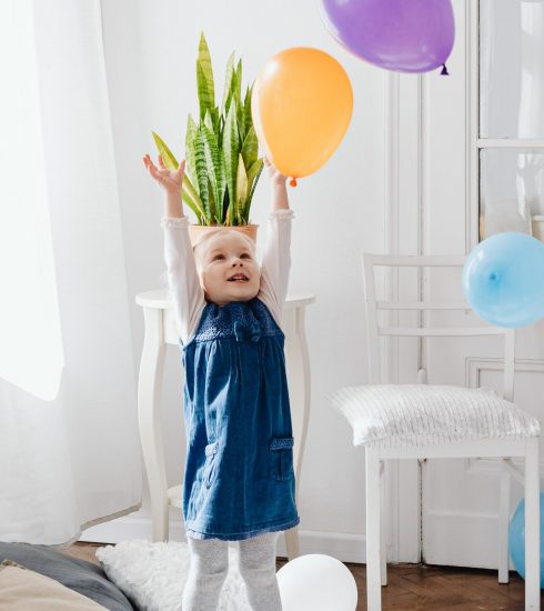 Maedchen greift nach Luftballons