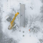 Ein Kran lädt einen Seecontainer für ein Tiny House ab