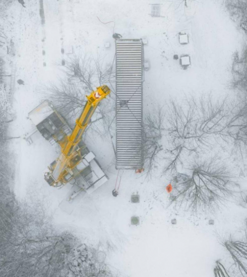 Ein Kran lädt einen Seecontainer für ein Tiny House ab